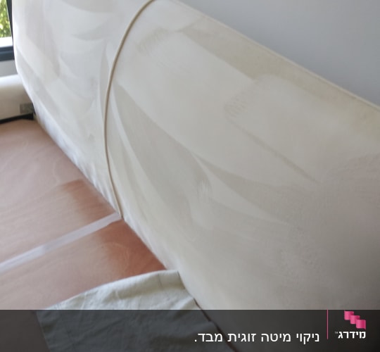 ספה לבנה עם כתמים, מטלית על הרצפה